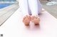 A woman sitting on a yoga mat with her feet up.