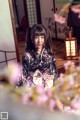 A woman in a kimono sitting in front of a window.