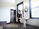 A woman in a black bodysuit standing in front of a sink.