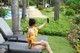 A woman sitting on a lounge chair taking a picture of herself.