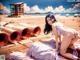 A woman in a bikini laying on a beach next to a lifeguard tower.