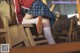 A woman in a school uniform is sitting on a chair.